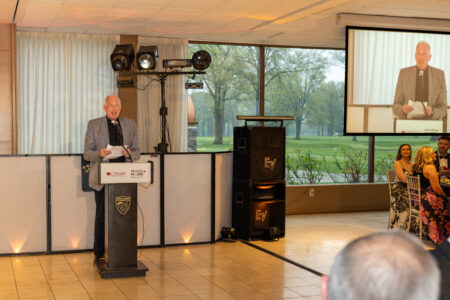 Reverend Ronald J. Wearsch - Keynote speaker/opening prayer presenting at a podium during a Cleveland corporate gala and non-profit fundraiser in Cleveland.